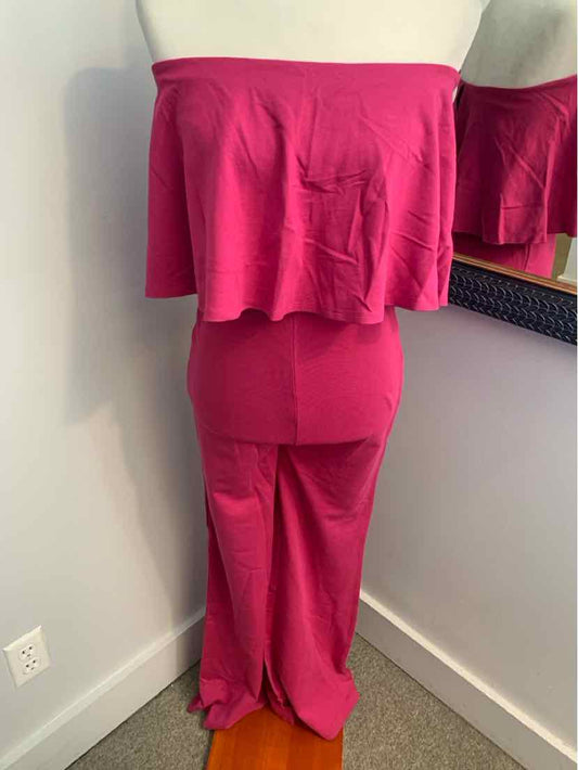 Pink off-shoulder strapless jumpsuit with ruffled overlay and wide-leg pants.