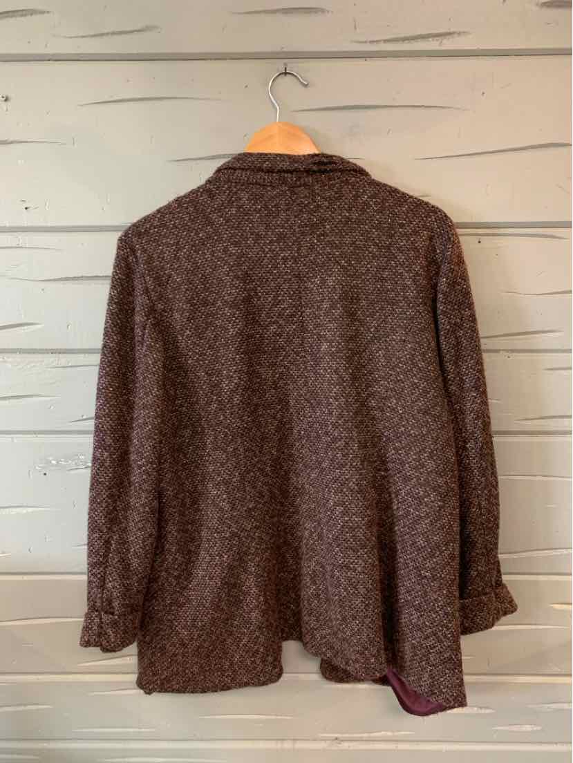 Burgundy tweed blazer with a relaxed fit and long sleeves, hanging on a wooden hanger.