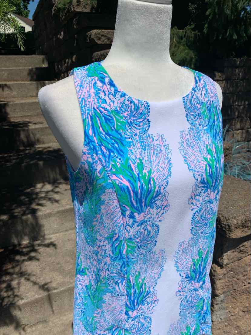 Sleeveless shift dress with blue, green, and purple coral reef pattern on white fabric.