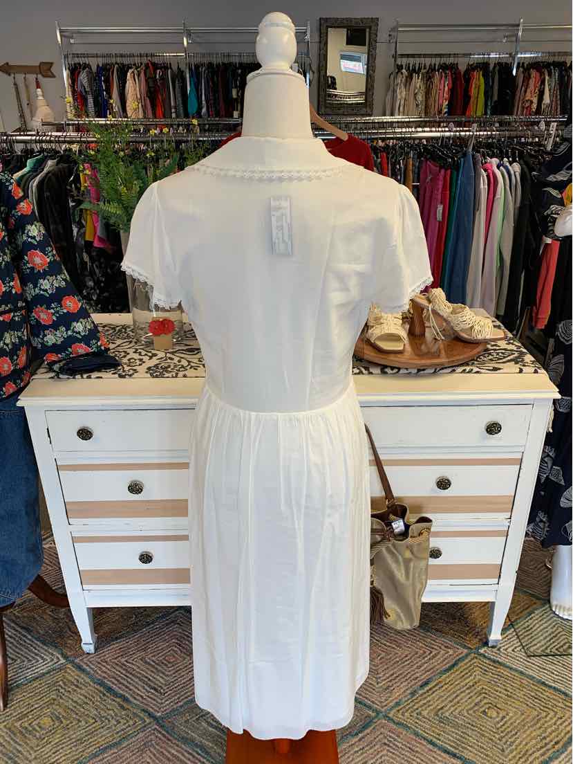 White short-sleeve midi dress with cinched waist and back keyhole detail on mannequin.