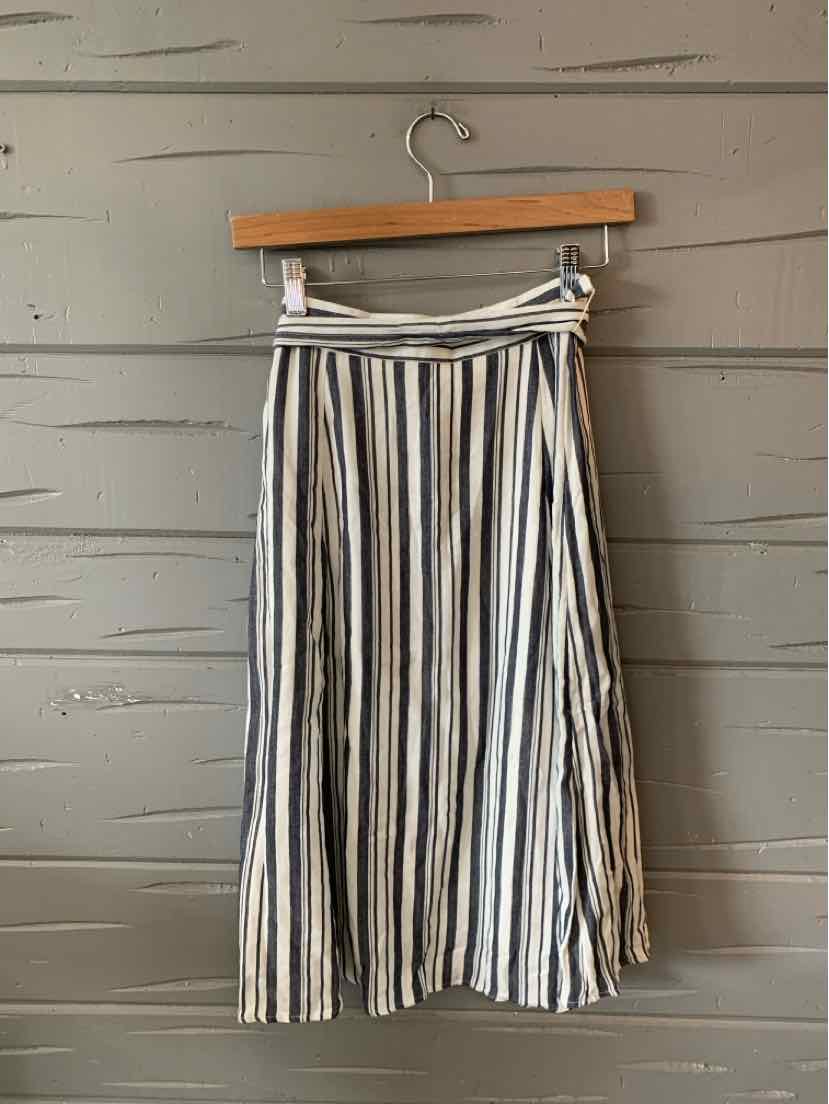 High-waist midi skirt with vertical black, white, and beige stripes and a flowy silhouette.