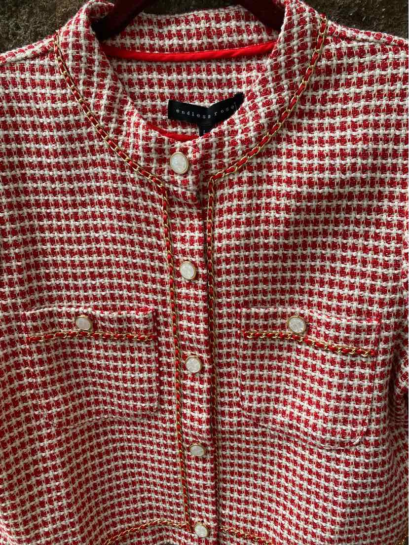 Red and white tweed jacket with stand collar and front pearl buttons, chest flap pockets.