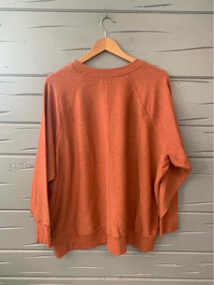 Rust-colored long-sleeve knit sweater with ribbed cuffs and hem, relaxed fit, size 1X.