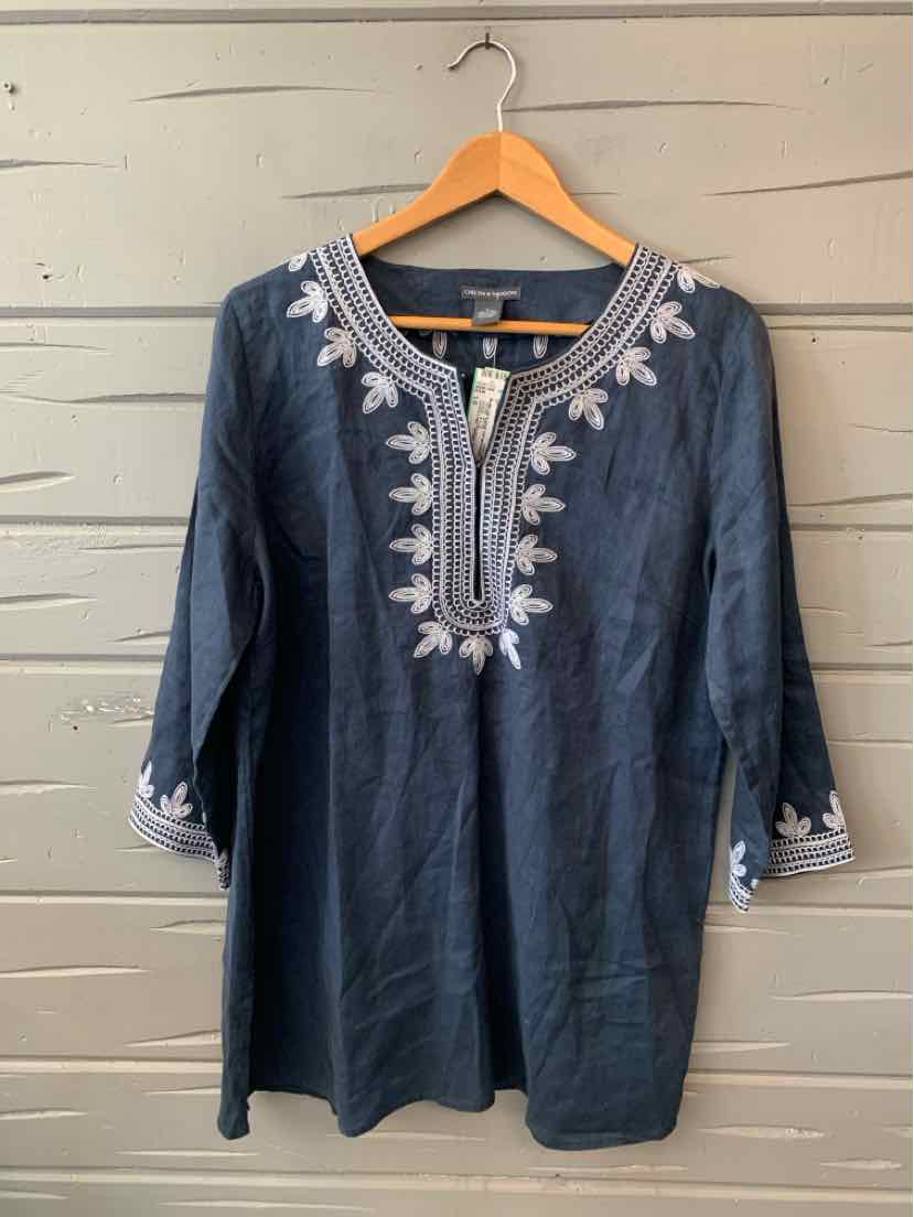 Navy blue long-sleeve tunic with white floral embroidery along neckline and cuffs on wooden hanger.