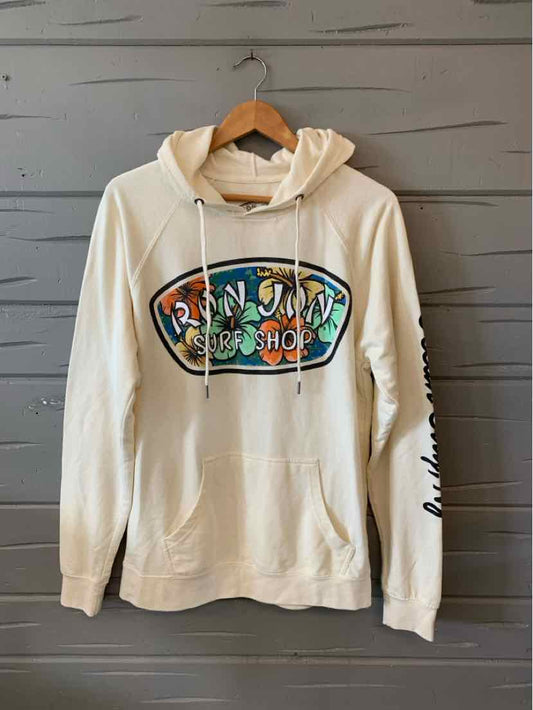 Cream-colored hooded sweatshirt with large colorful "Ron Jon Surf Shop" graphic on front and black script text on left.