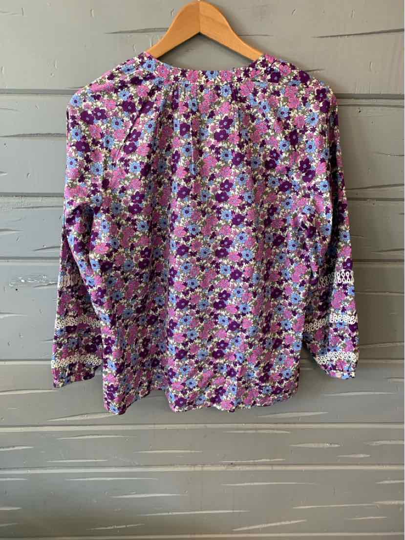Long-sleeve floral blouse in pink, purple, and white with a round neckline and button detail at the back.