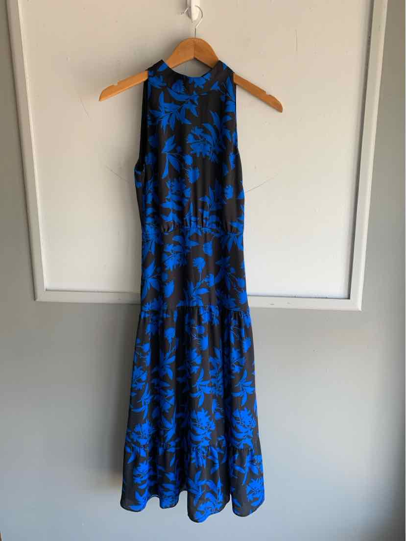 Black sleeveless maxi dress with blue floral print and flowy skirt on wooden hanger.