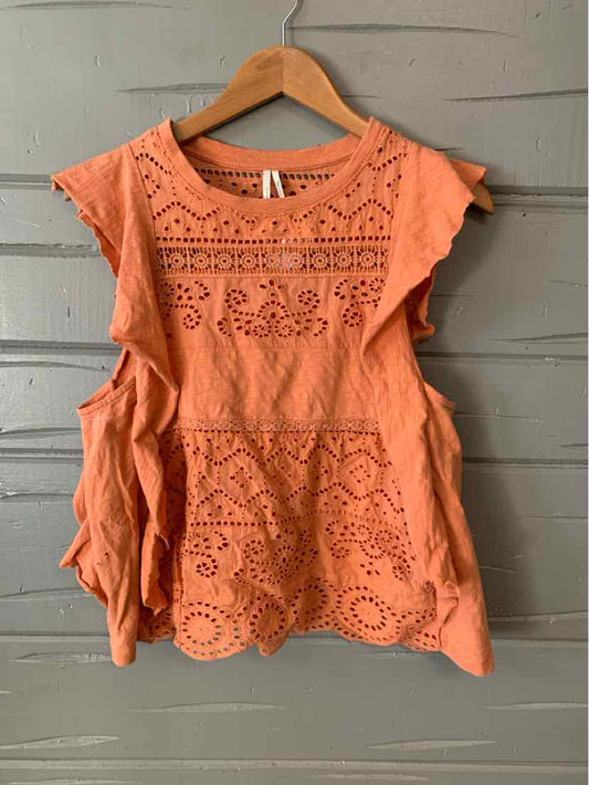 Orange sleeveless eyelet blouse with scalloped hem and intricate cutout floral patterns.