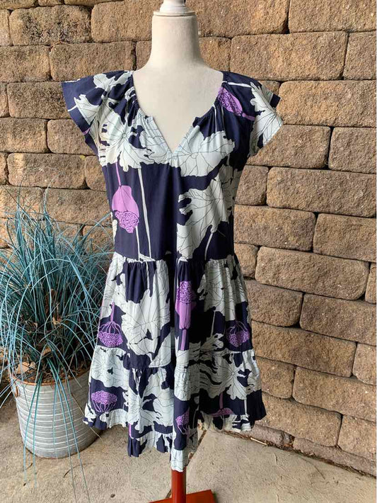 Short-sleeve floral dress with purple, white, and black pattern, tiered skirt, and V-neckline.