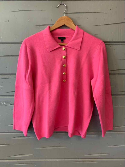 Pink long-sleeve polo sweater with gold buttons and ribbed cuffs hanging on wooden hanger.