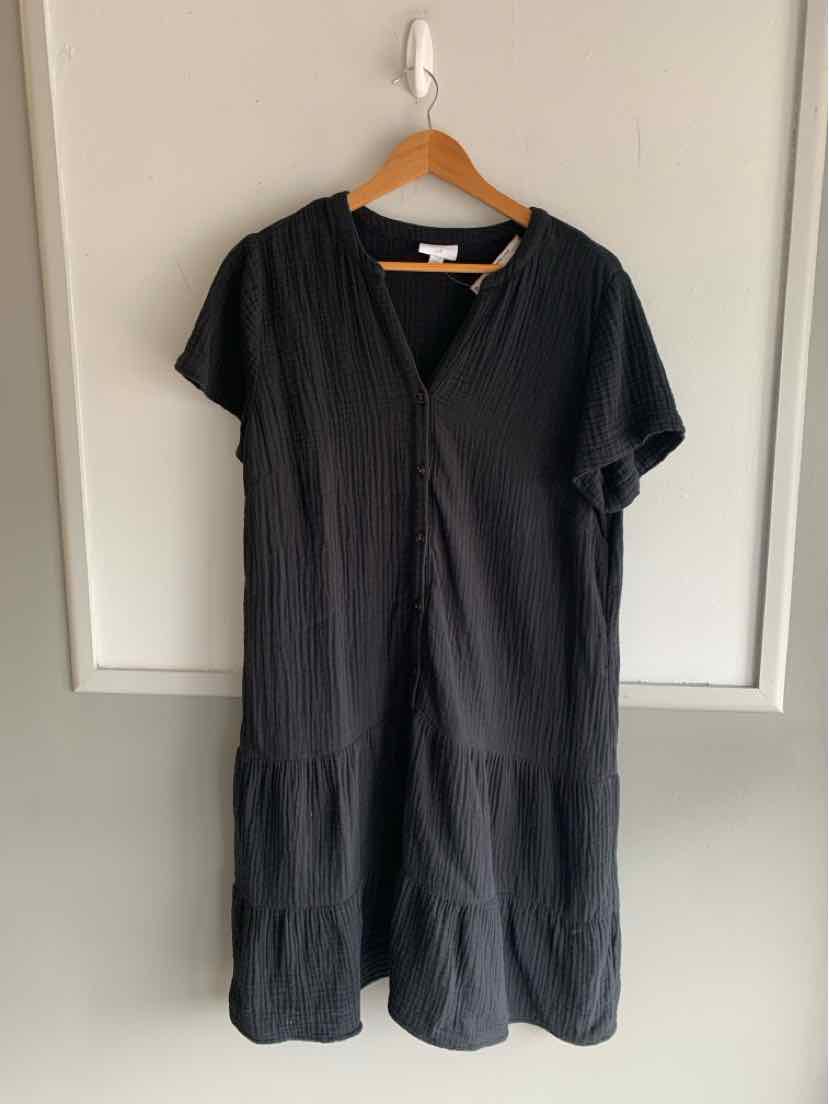 Black short-sleeve midi dress with v-neck and tiered ruffle hem on wooden hanger.