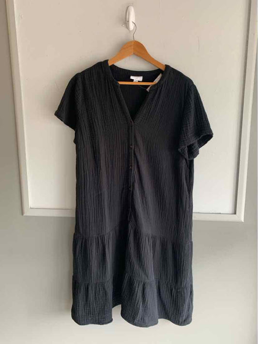 Black short-sleeve midi dress with v-neck and tiered ruffle hem on wooden hanger.