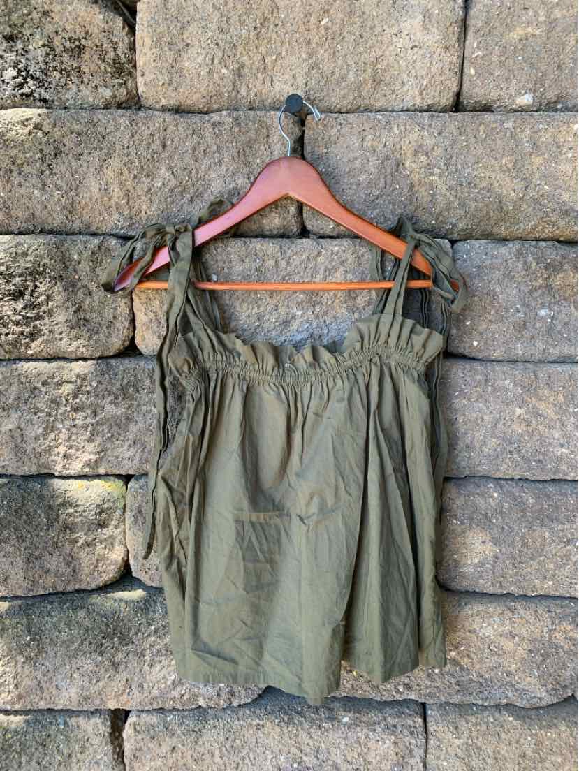 Olive green sleeveless blouse with ruffled neckline and adjustable tie straps on wooden hanger.