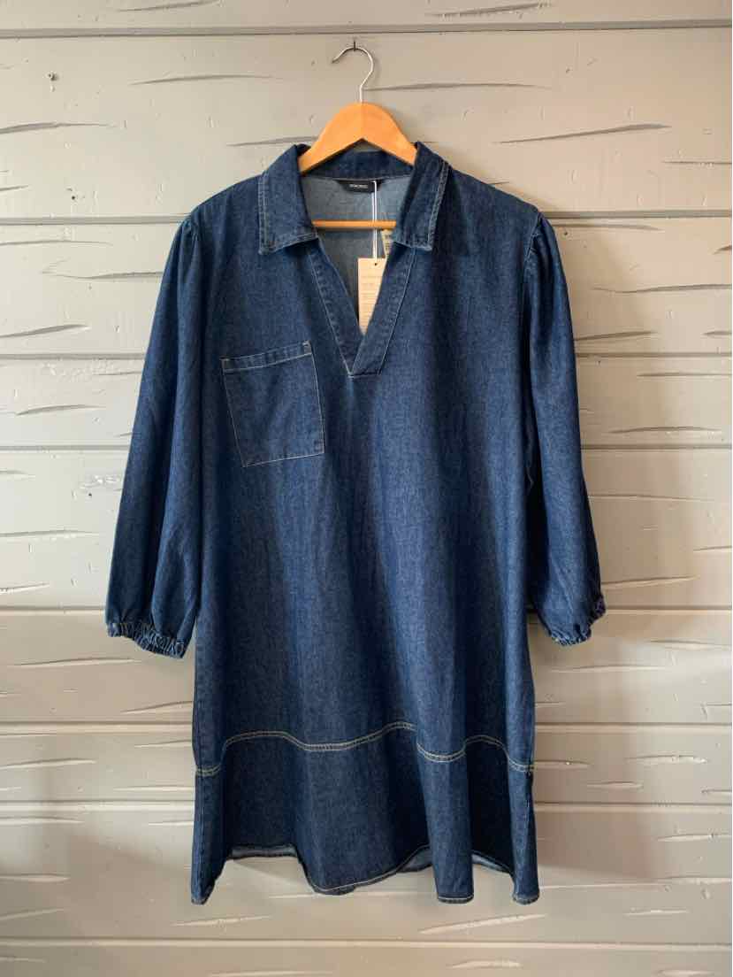 Dark blue oversized denim dress with long sleeves, V-neck collar, and front patch pocket.