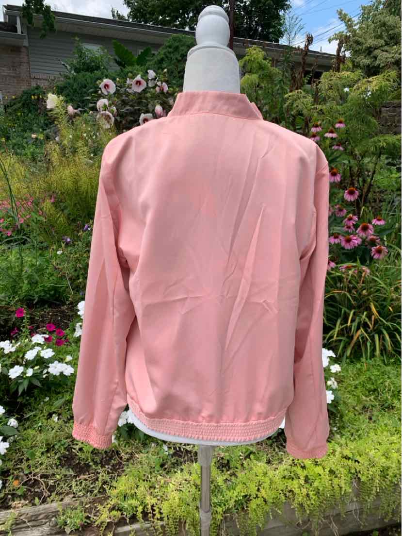 Light pink denim jacket with long sleeves and classic collar on a dress form outdoors.