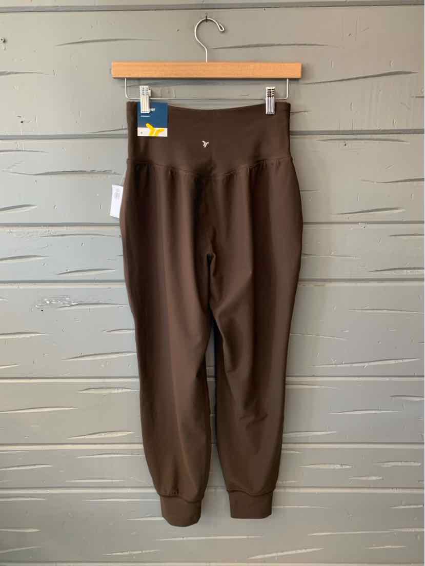 Dark brown Old Navy women’s leggings with a wide waistband and tapered ankle cuffs, hanging on a wooden hanger.