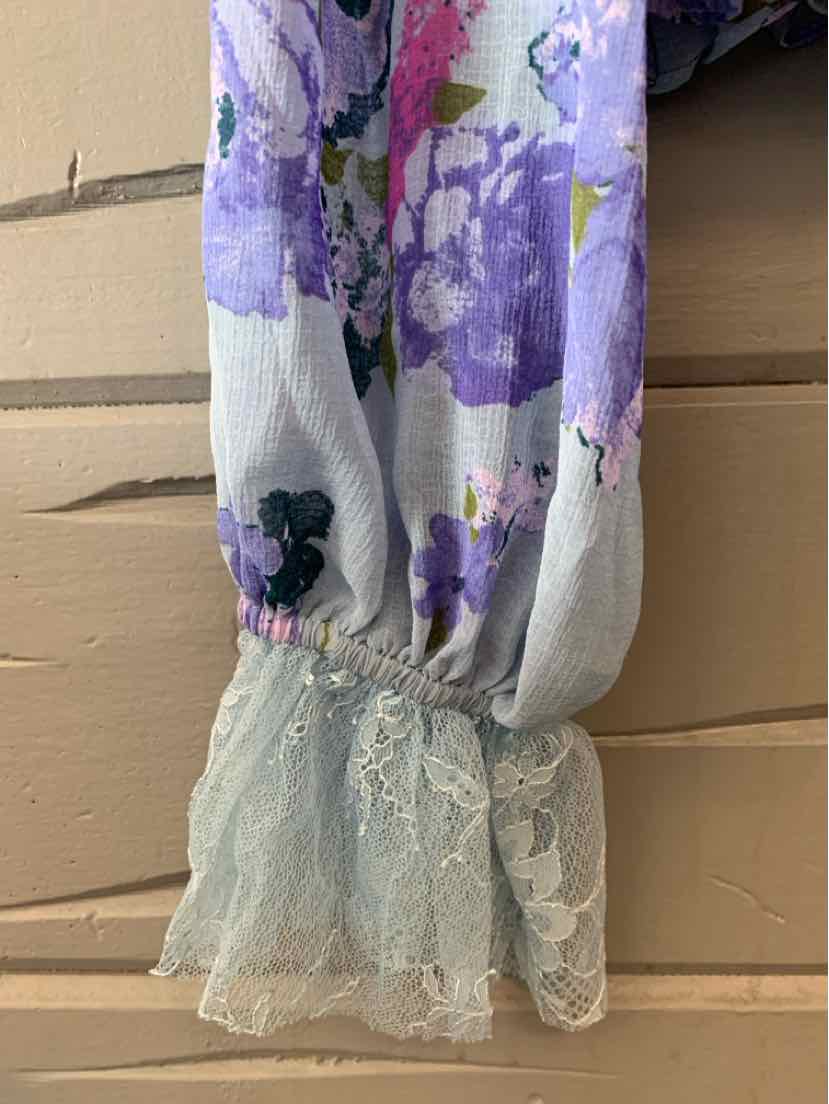 White and purple floral blouse sleeve with lace cuff detail and gathered elastic wrist.
