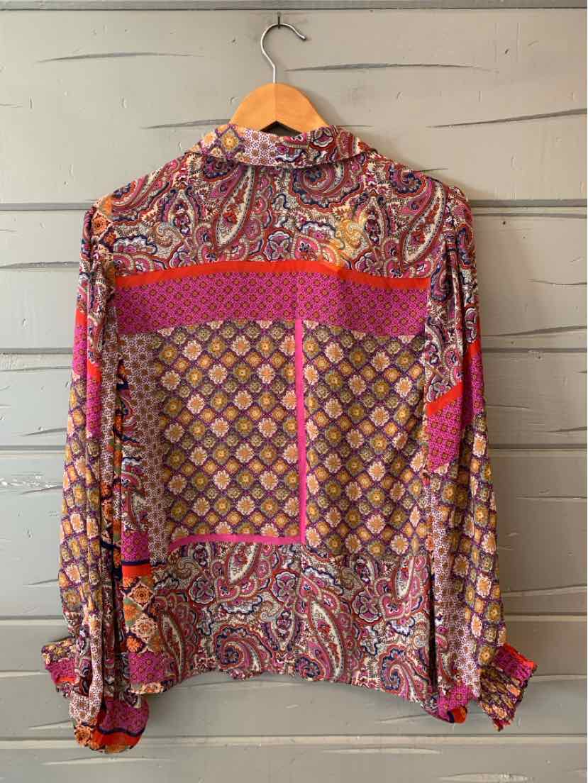 Long-sleeve multicolor blouse with paisley and geometric patterns, button cuffs, and lightweight fabric.