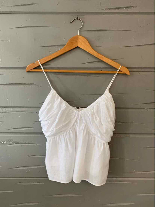 White sleeveless cotton camisole with ruched front and thin adjustable straps.
