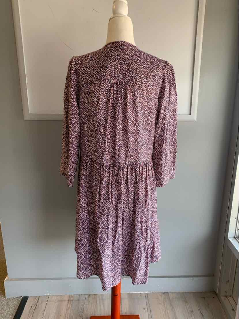 Blue midi dress with subtle floral pattern, long sleeves, fitted waist, gathered back detail.