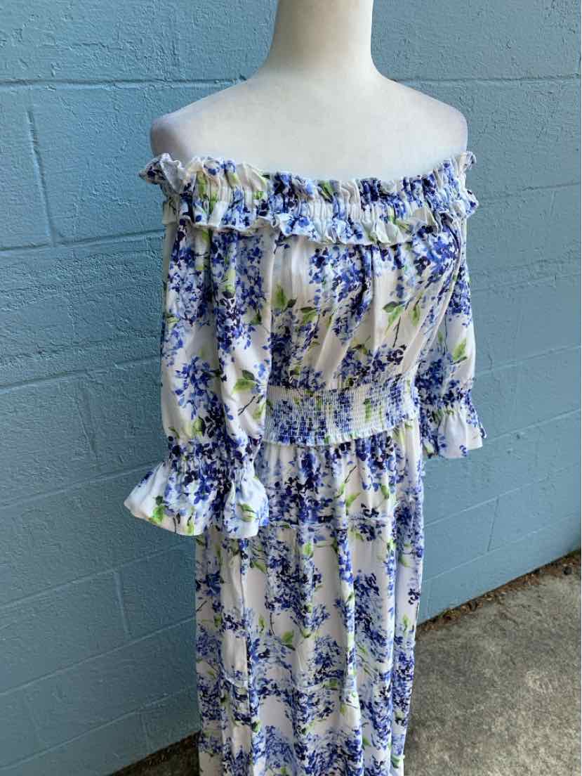 Off-shoulder floral dress with blue and green print, smocked bodice, and ruffled sleeves.