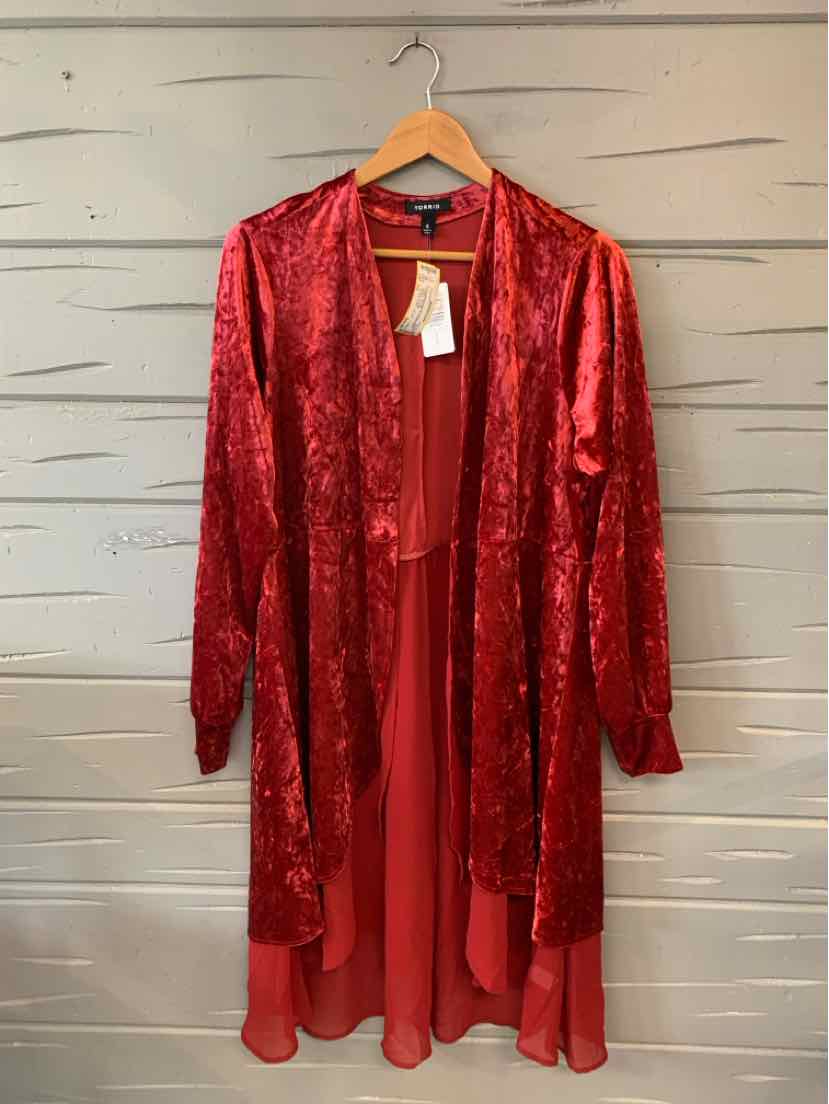 Long open-front red velvet cardigan with sheer chiffon hem and long sleeves hanging on wooden hanger.