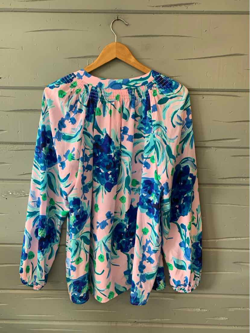 Long-sleeve blouse with vibrant blue and green floral print on light pink fabric, gathered neckline, and loose fit.