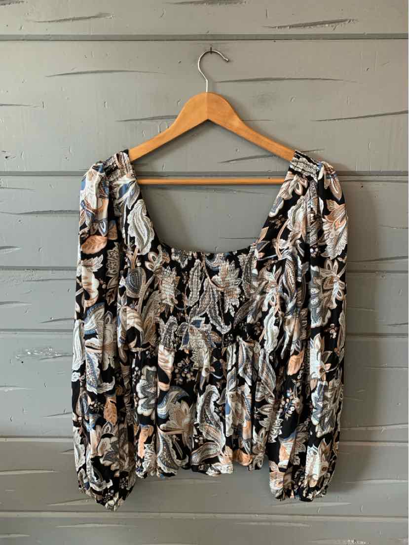 Black and beige floral long-sleeve blouse with ruched bodice and square neckline on wooden hanger.