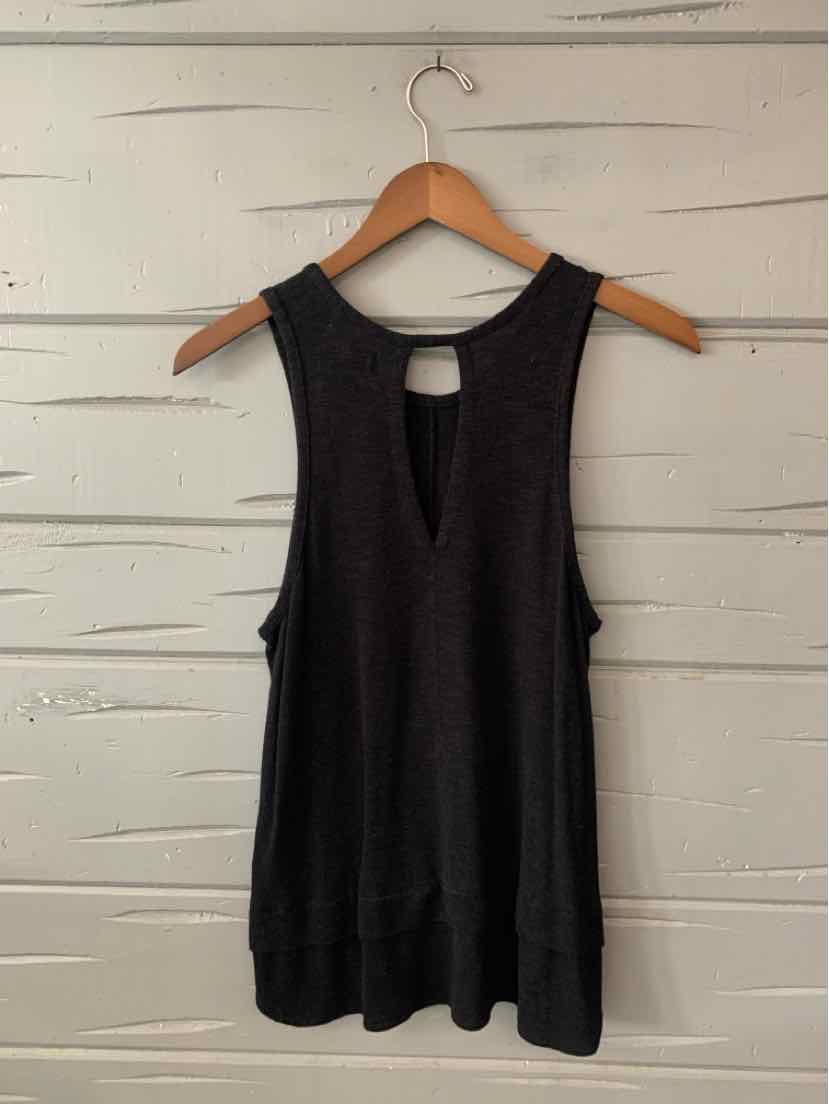 Black sleeveless tank top with round neckline, relaxed fit, and soft fabric hanging on wooden hanger.
