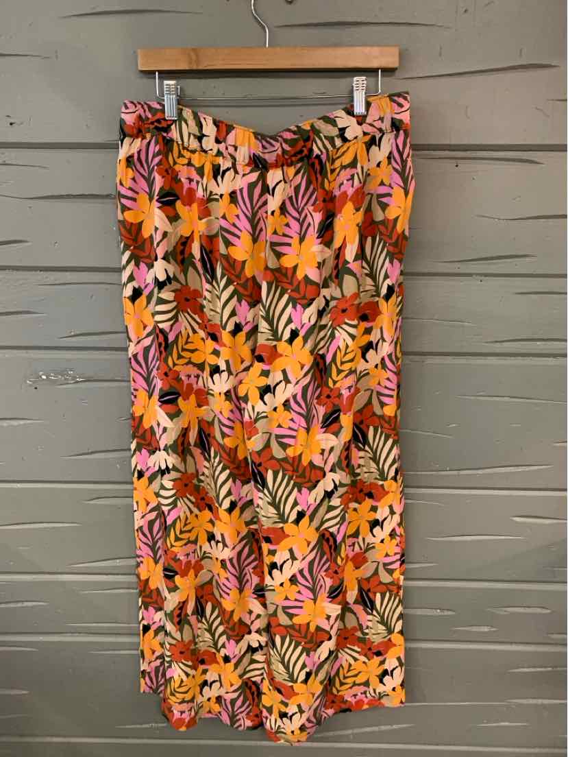 Floral skirt with orange, pink, and purple leaf pattern in large size hanging on wooden hanger.