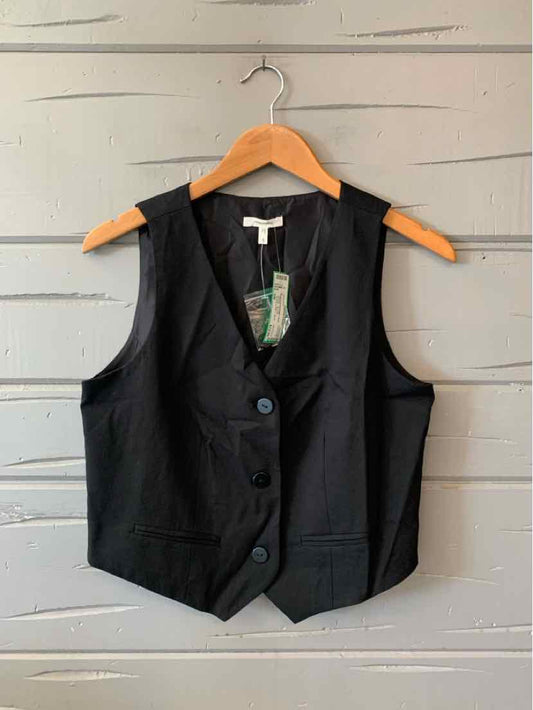 Black sleeveless tailored vest with three buttons and notched lapels on wooden hanger.