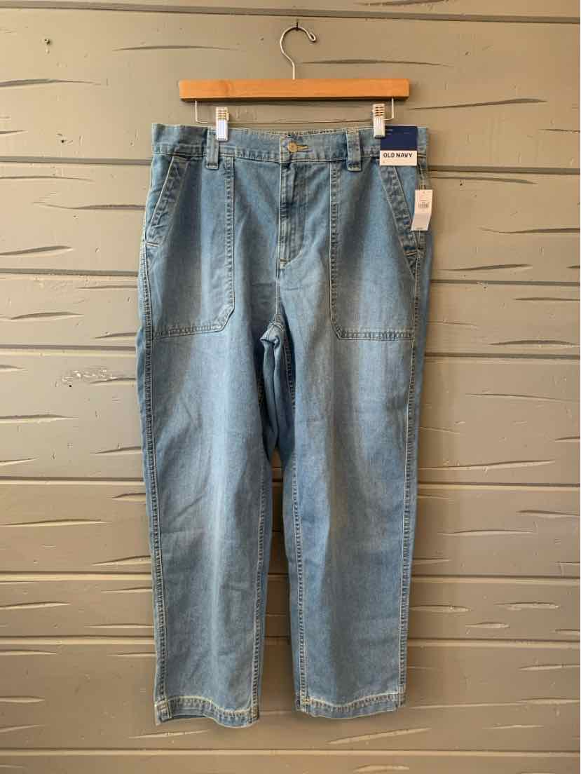 Light blue high-waisted denim jeans with patch pockets and straight legs hanging on wooden hanger.