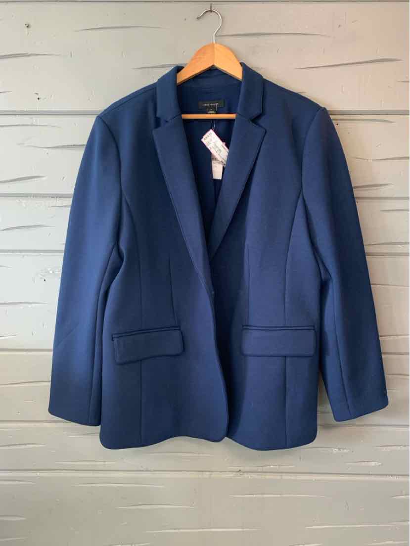 Navy blue tailored blazer with notch lapels, front flap pockets, and structured shoulders hanging on wooden hanger.