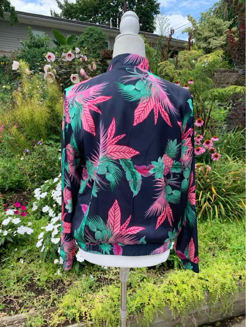 Navy blue tropical print long-sleeve shirt with pink and green palm leaves on mannequin.