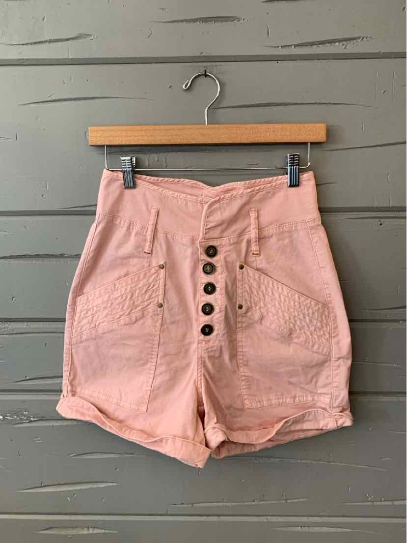 High-waist dusty pink shorts with front button closure and large side pockets, made of textured fabric.