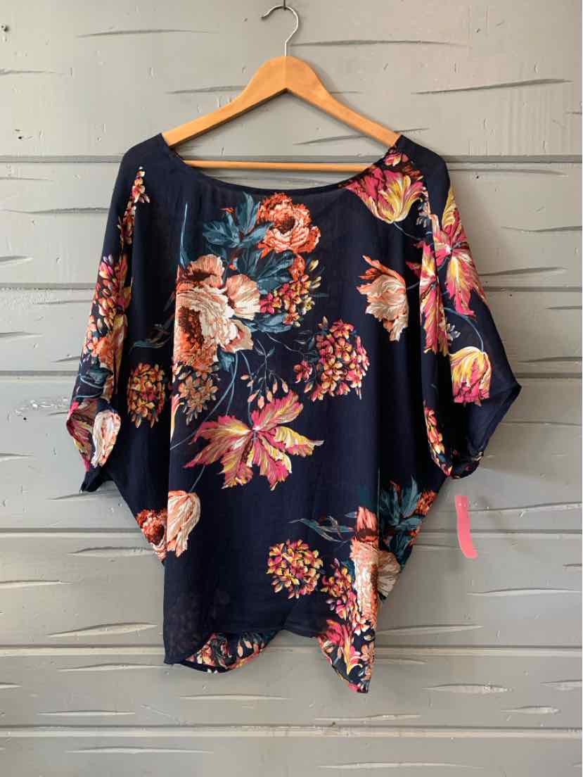 Navy blue blouse with pink and orange floral print and wide sleeves on wooden hanger.