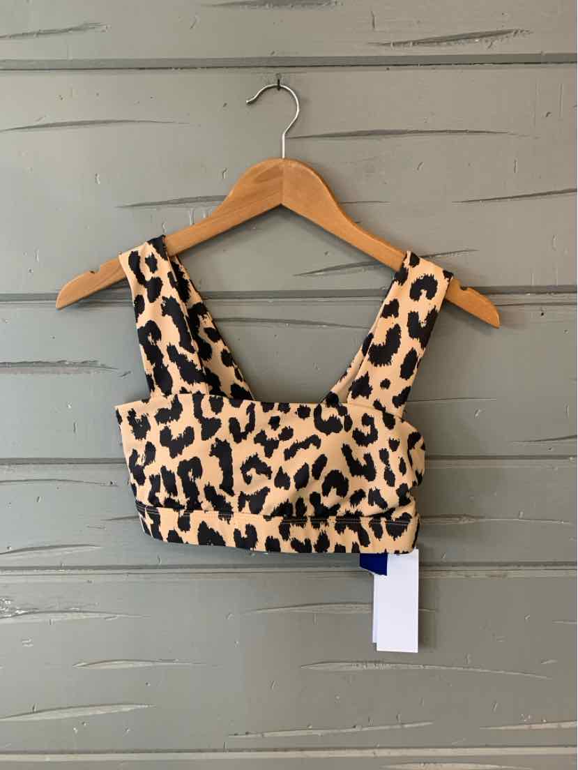 Tan cheetah print cropped tank top with wide straps hanging on wooden hanger.