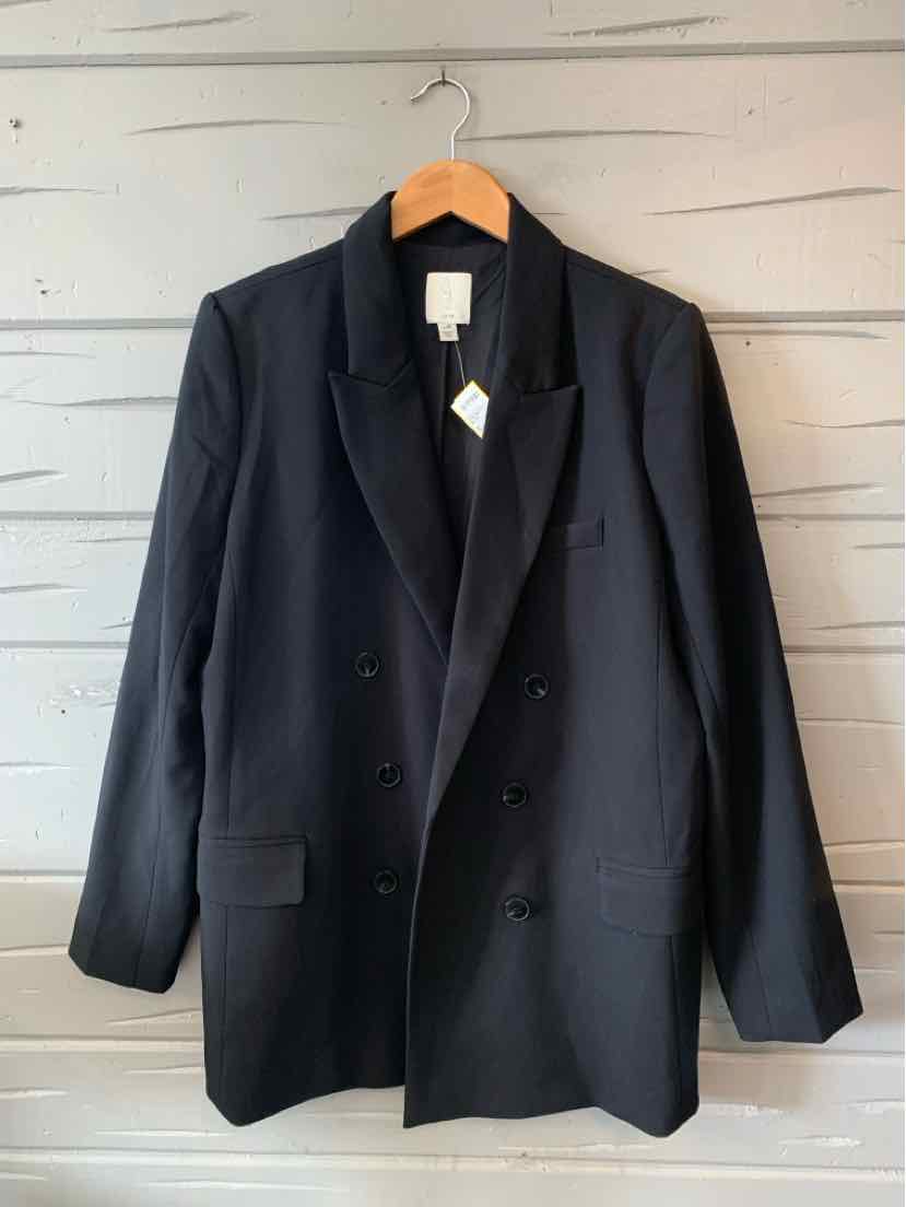 Black double-breasted blazer with notch lapels and front flap pockets, hanging on wooden hanger.