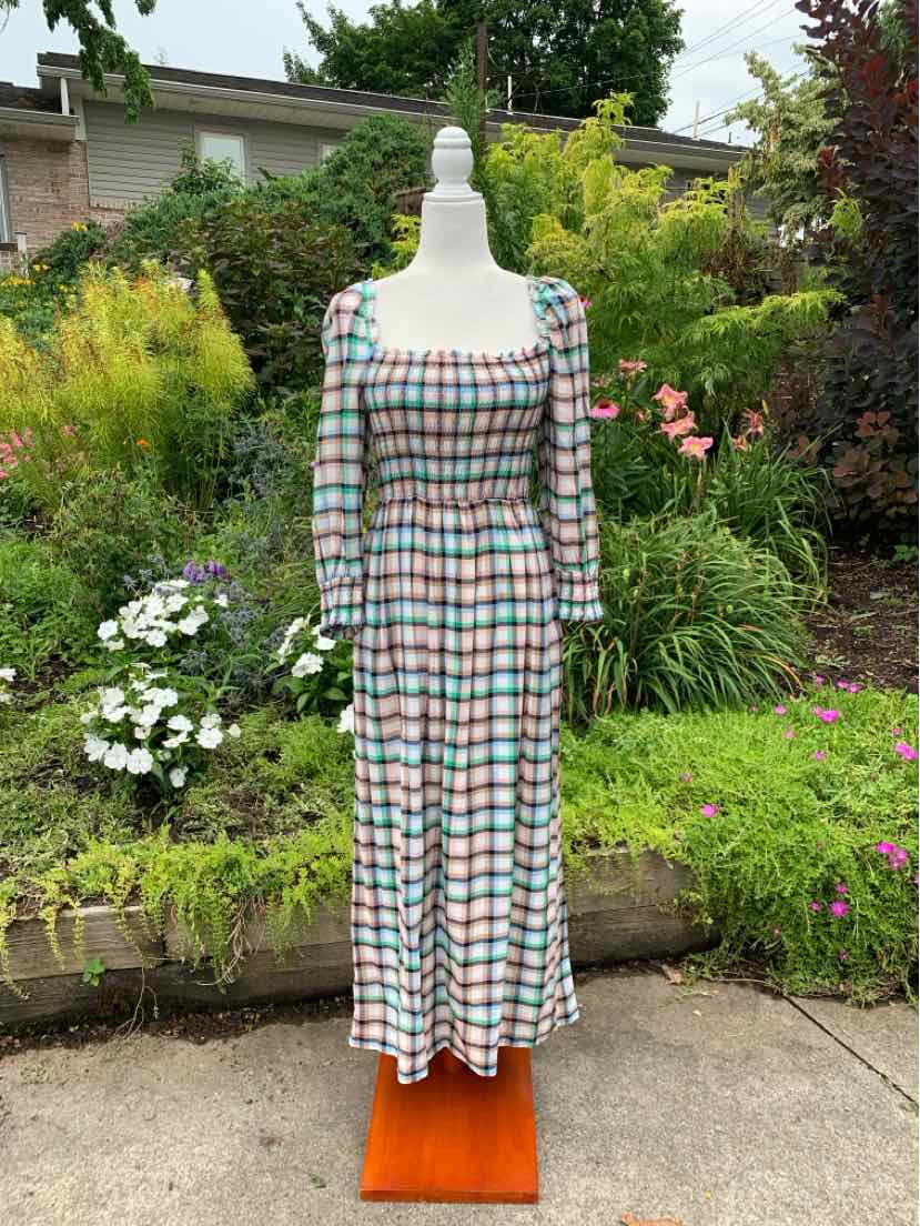 Long plaid dress with square neckline and long sleeves in multicolored pastel tones.