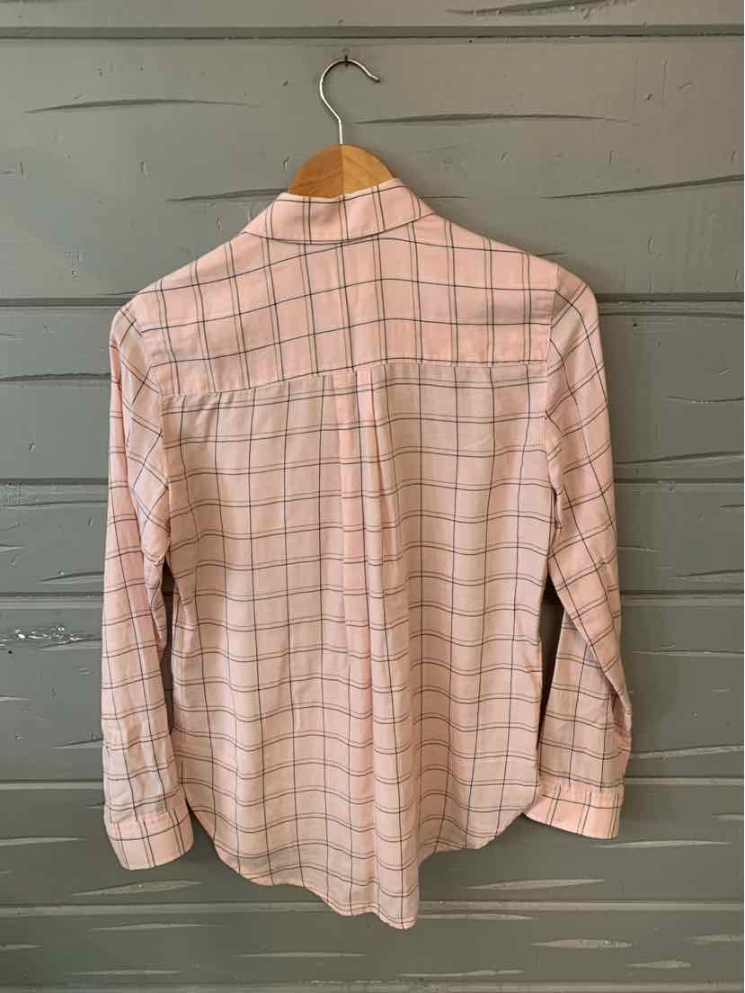 Light pink plaid shirt with long sleeves and buttoned cuffs, hanging on wooden hanger.