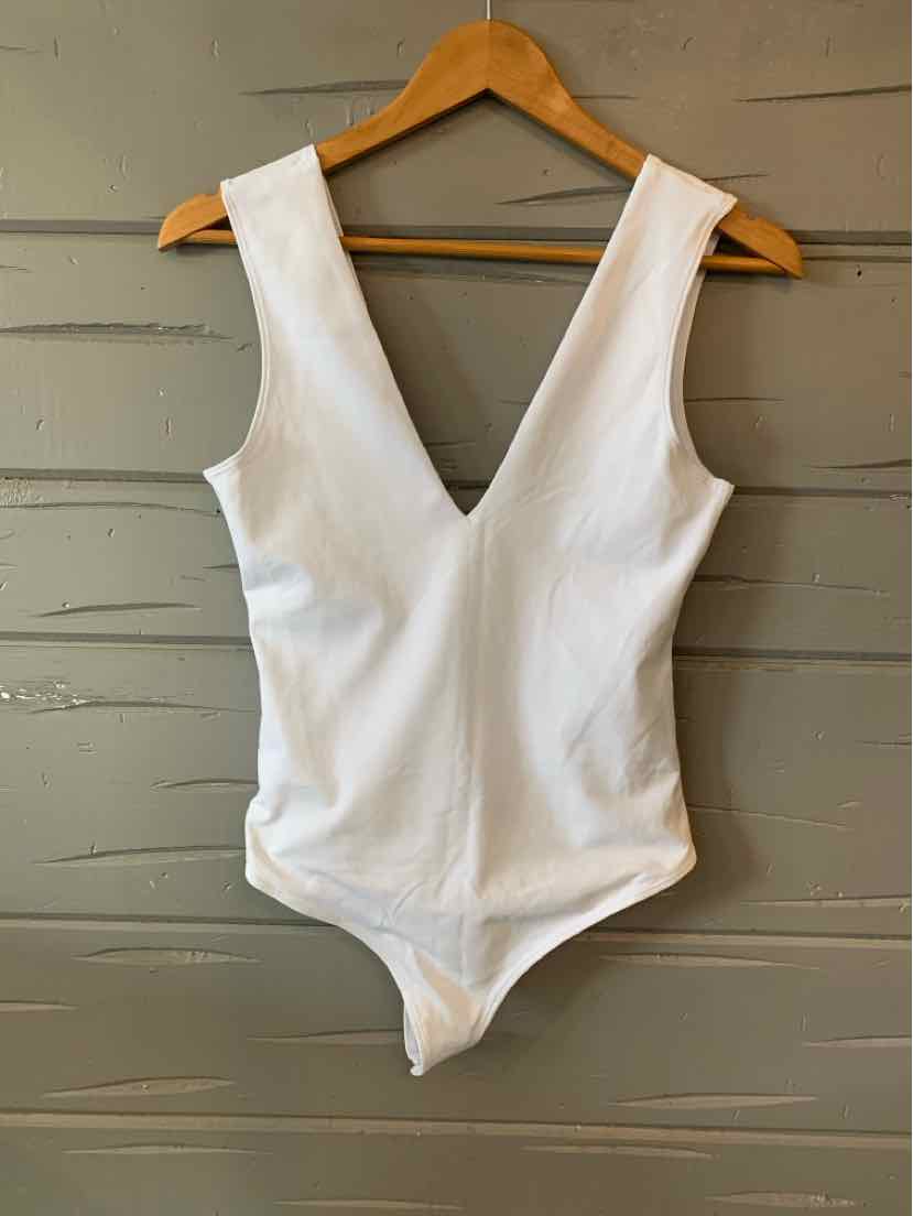 White sleeveless bodysuit with deep V-neck and fitted waist on wooden hanger.