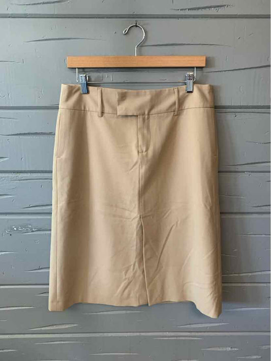Tan knee-length skirt with a straight silhouette and minimal design hanging on wooden hanger.