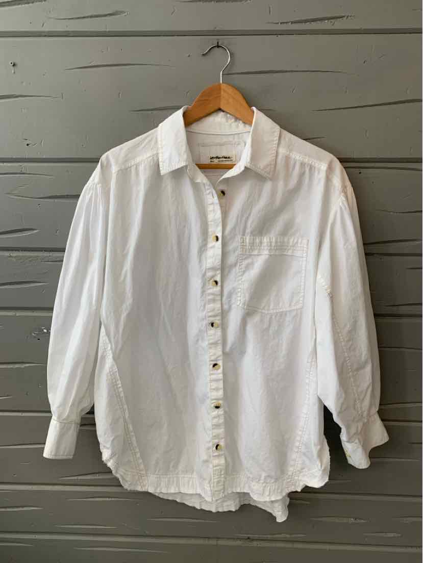 White long-sleeve button-up shirt with collar and single chest pocket on wooden hanger.