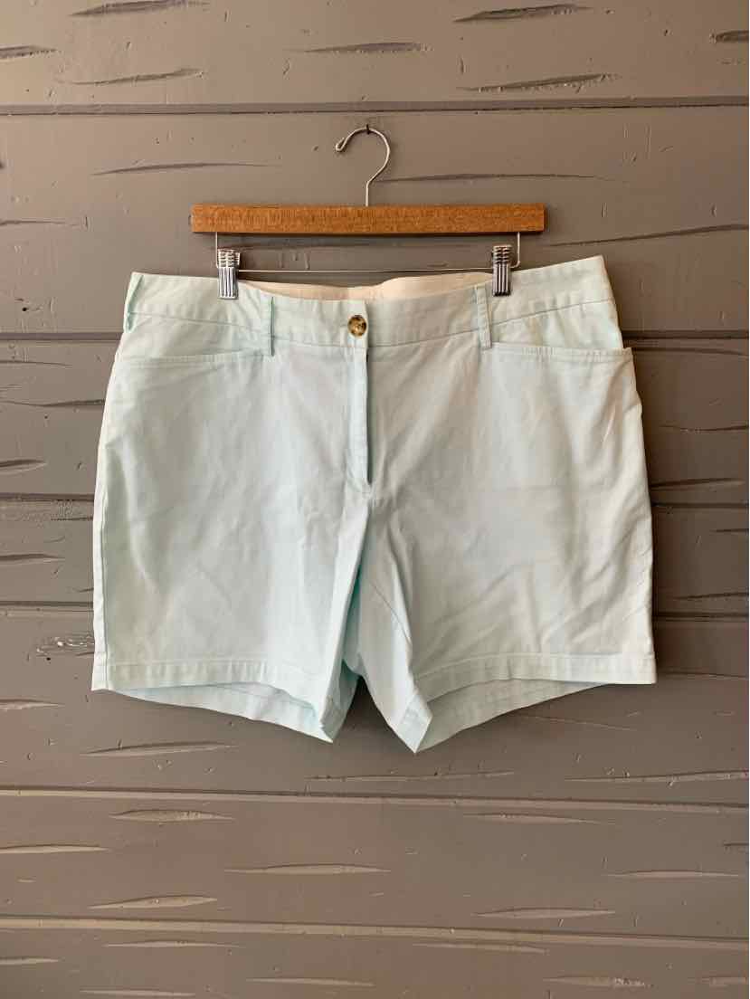 White cotton shorts with front button and zipper closure, side pockets, size 16W, displayed on wooden hanger.