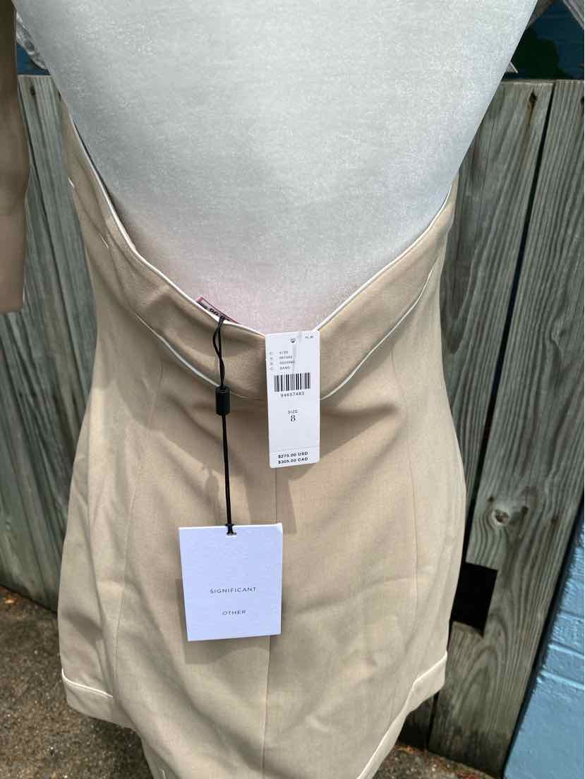 Tan high-waisted skirt with straight cut and attached black and white tags hanging from waistband.