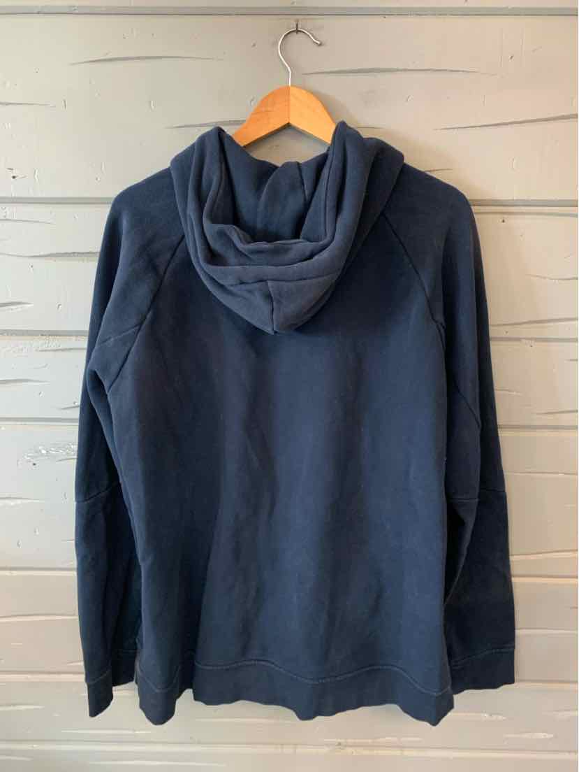 Navy blue hoodie with kangaroo pocket and drawstring hood hanging on wooden hanger.