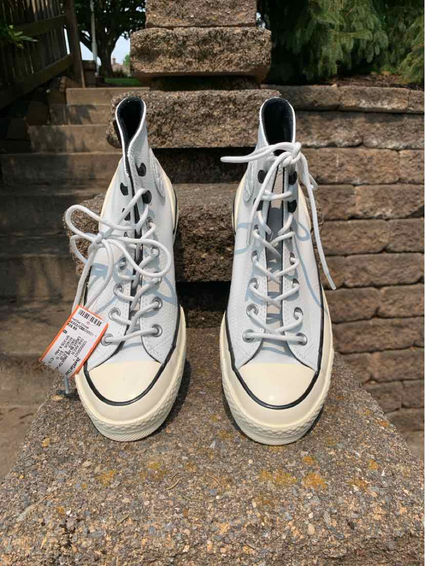 Pair of white high-top Converse sneakers with black trim and white laces, size 8.