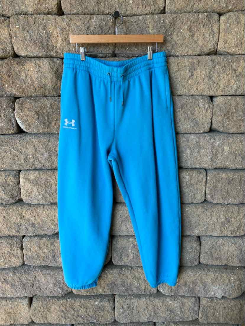 Bright blue Under Armour pants with an elastic waistband, drawstring, and tapered legs.