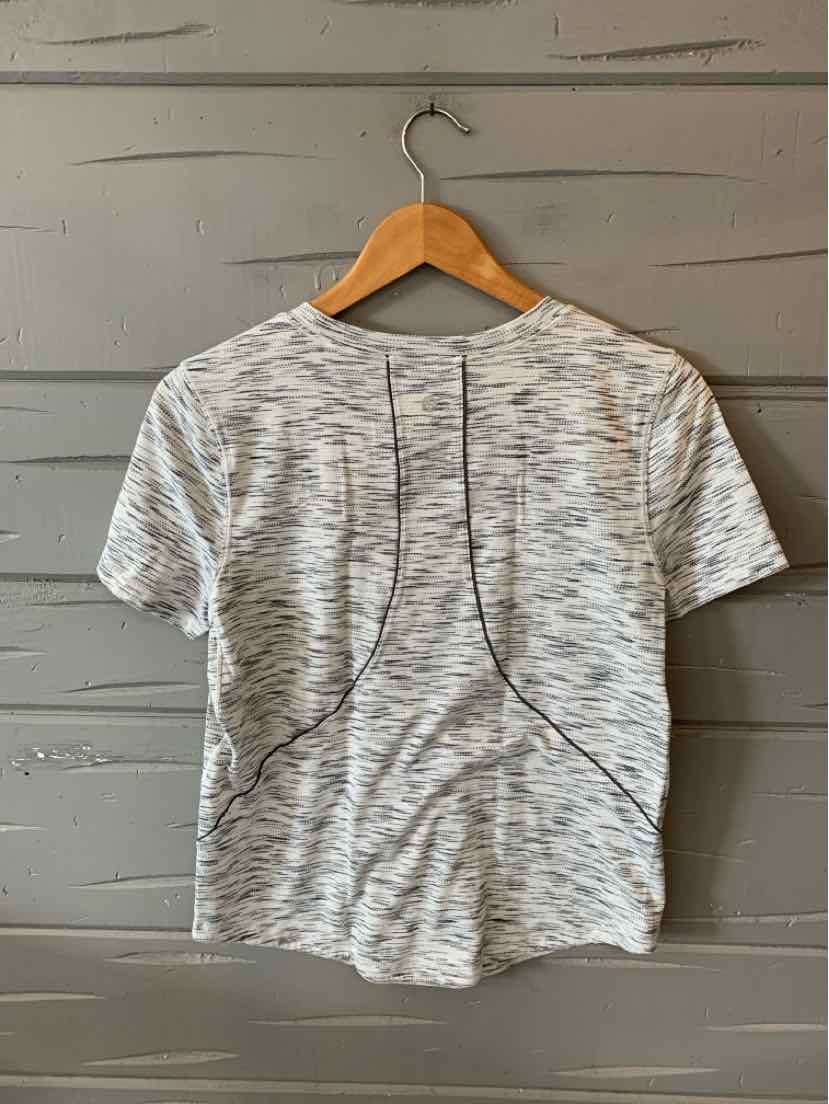 Light gray heathered short-sleeve athletic top with curved seam details and a round neckline hanging on wooden hanger.