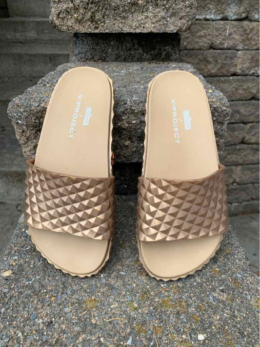 Metallic bronze slide sandals with quilted texture on wide straps and beige footbeds, size 7.